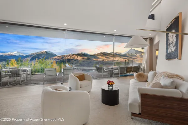 a living room with furniture a fireplace and a large window