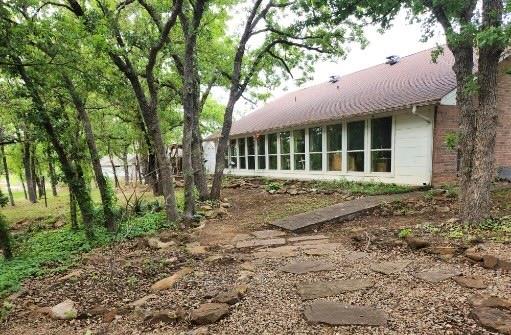 1149 Country Club Road Bowie, TX 76230 - Photo 6 of 17 a front view of a house with a garden
