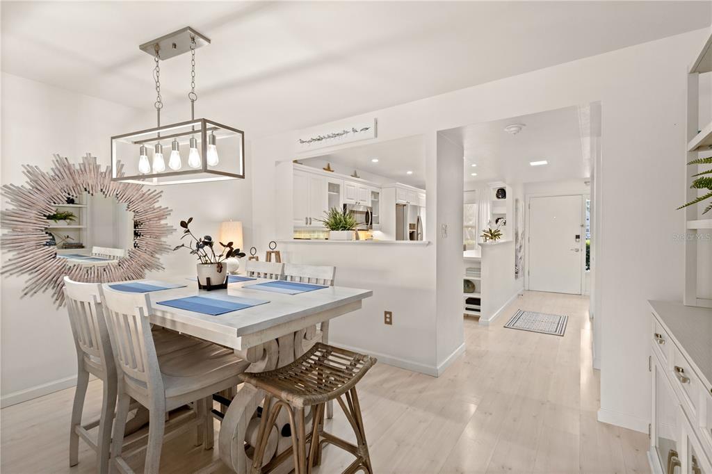 8630 Midnight Pass Road, Unit 103A Sarasota, FL 34242 - Photo 15 of 44 a view of a dining room and livingroom with furniture wooden floor a chandelier