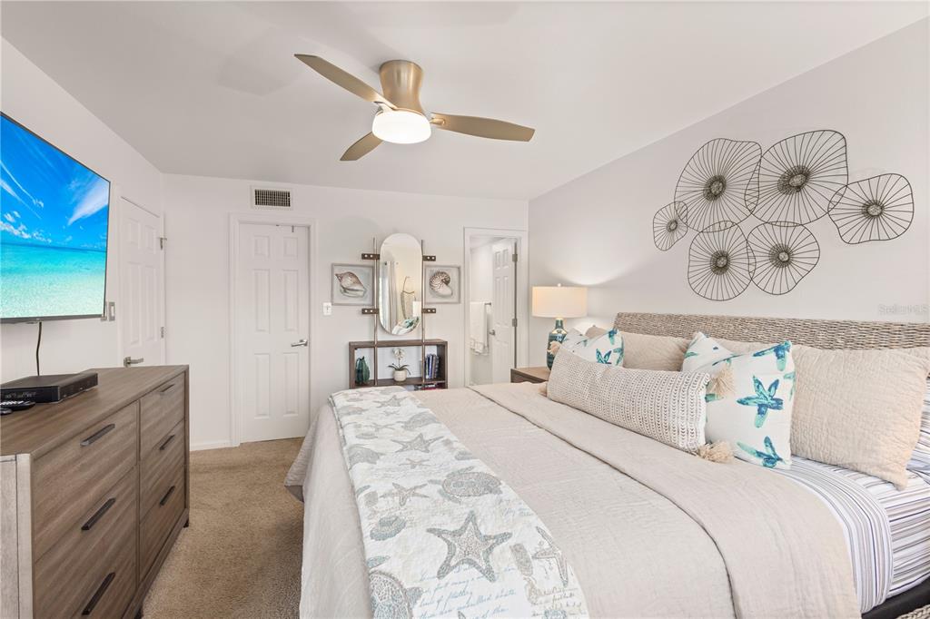 8630 Midnight Pass Road, Unit 103A Sarasota, FL 34242 - Photo 3 of 44 a bedroom with a bed and a lamp on dresser