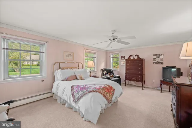 a spacious bedroom with a bed a chandelier and a large window