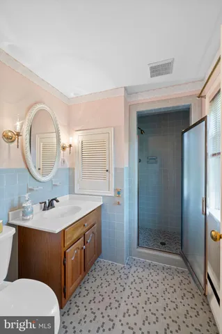 a bathroom with a sink a toilet a mirror and shower