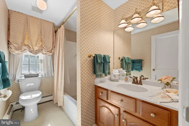 a view of bathroom with a toilet sink and mirror