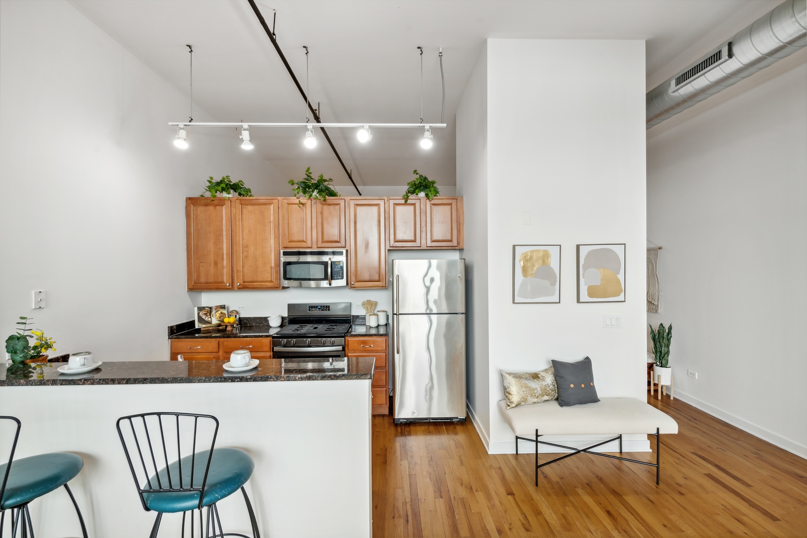 1224 West Van Buren Street, Unit 810 Chicago, IL 60607 - Photo 8 of 28 a kitchen with stainless steel appliances granite countertop a dining table chairs refrigerator and microwave