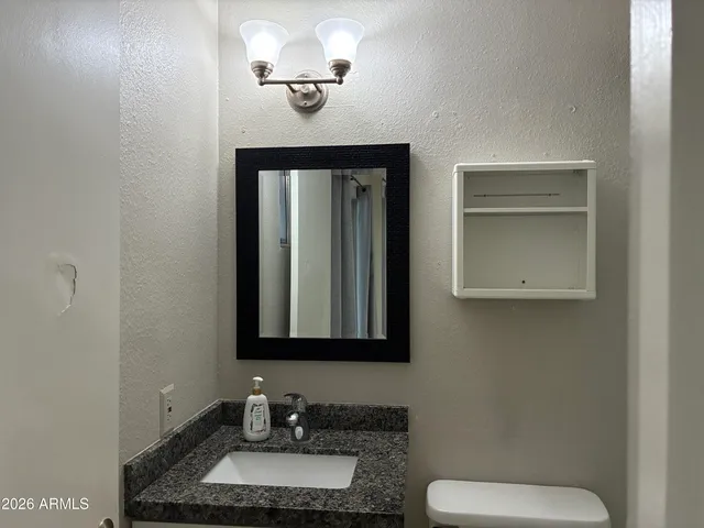 a bathroom with a toilet sink and mirror