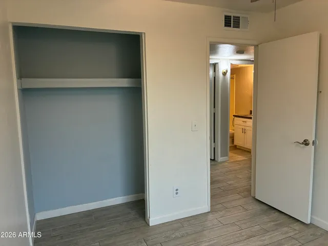 a view of an empty room with wooden floor