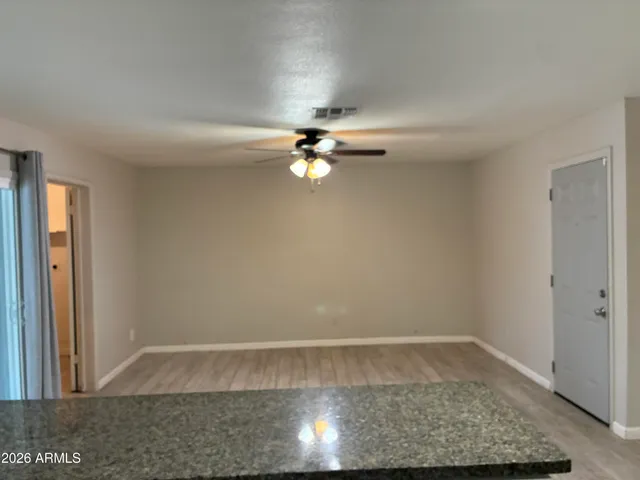 a view of a livingroom with a ceiling fan and hardwood floor