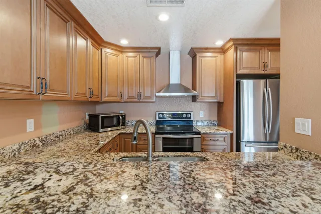 a view of an empty room with wooden floor and windows