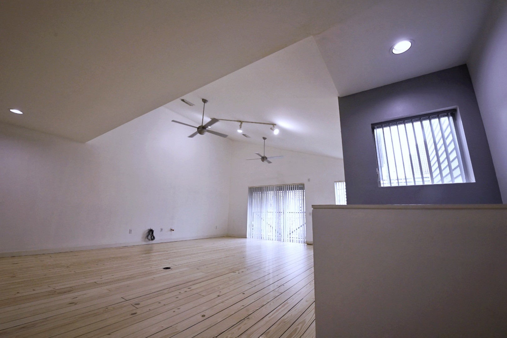 702 Ruthven Street Houston, TX 77019 - Photo 11 of 18 an empty room with wooden floor chandelier fan and windows
