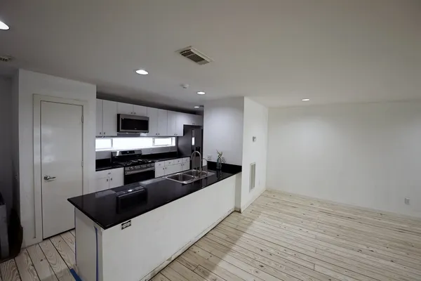 an empty room with wooden floor and ceiling fan