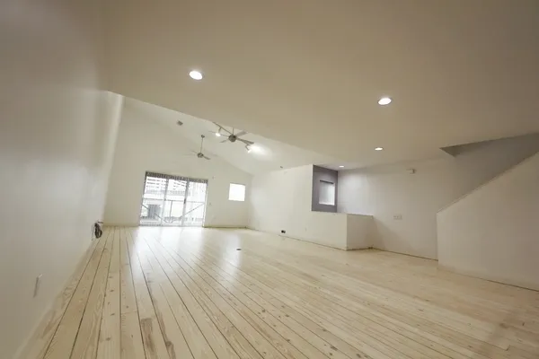 a view of empty room with window and wooden floor