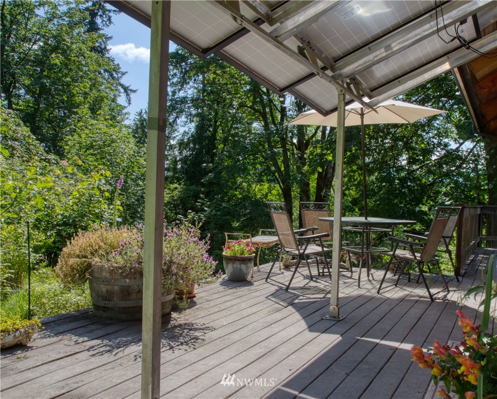 2707 Dabob Road Quilcene, WA 98376 - Photo 21 of 36 a view of deck with table and chairs under an umbrella with wooden floor