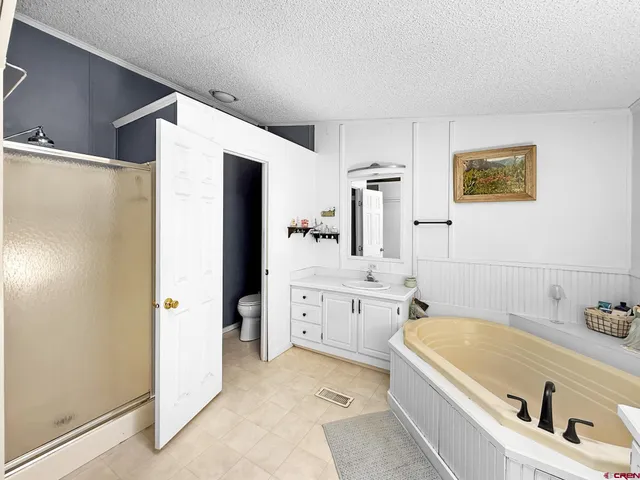a bathroom with a granite countertop tub sink and mirror