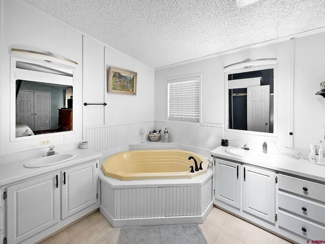 a bathroom with a tub sink and mirror