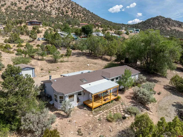 an aerial view of a house with yard and mountain view in back