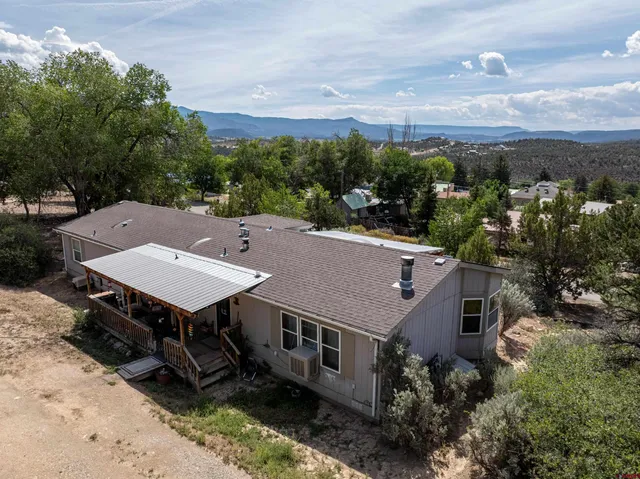 an aerial view of a house with roof deck outdoor seating and green space