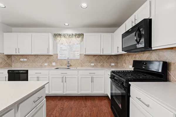 a kitchen with stainless steel appliances granite countertop a sink a stove a microwave and cabinets
