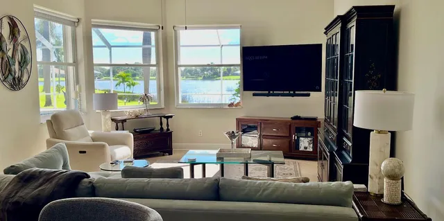 a living room with furniture a flat screen tv and a window