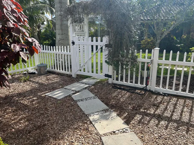 a view of a brick house with a small yard and large trees