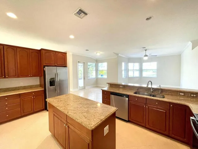 a kitchen with stainless steel appliances granite countertop a sink stove and refrigerator