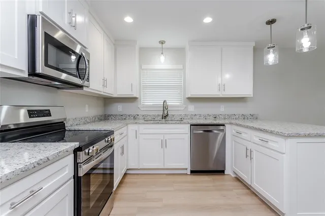 a kitchen with stainless steel appliances granite countertop a sink and stove top oven