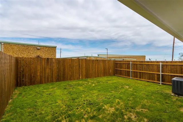a view of a backyard with wooden fence