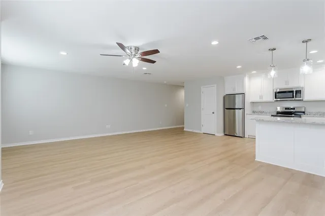a view of kitchen with granite countertop cabinets and refrigerator