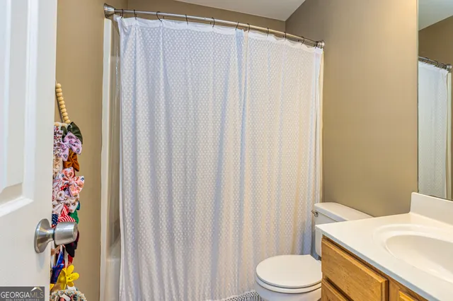 a white toilet sitting next to a shower curtain