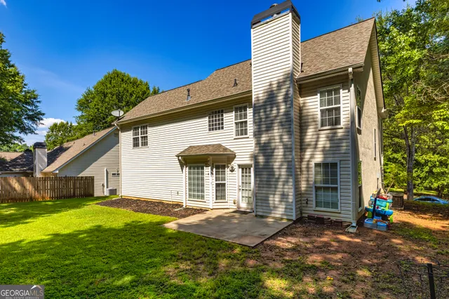 a view of a house with backyard and sitting area