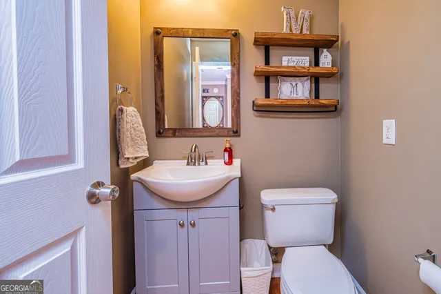 a bathroom with a sink toilet and a mirror