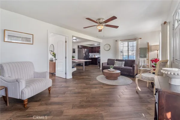 a living room with furniture kitchen view and a window