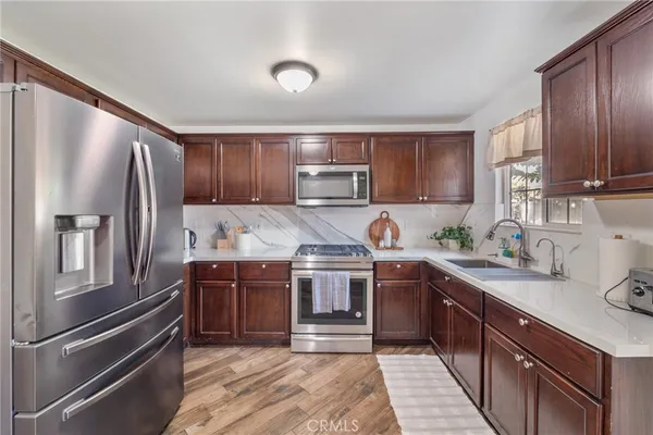 a kitchen with stainless steel appliances granite countertop a refrigerator and a stove top oven