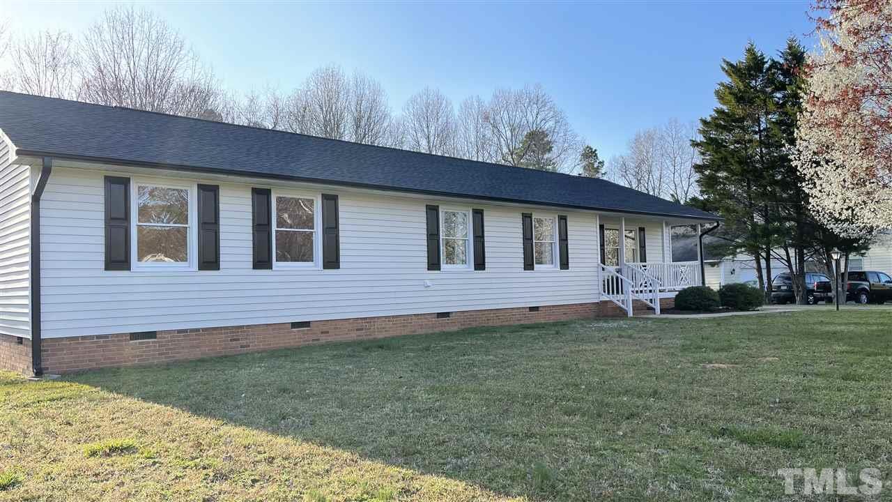 7009 Kiger Road Rougemont, NC 27572 - Photo 2 of 25 a backyard of a house with wooden fence and large trees