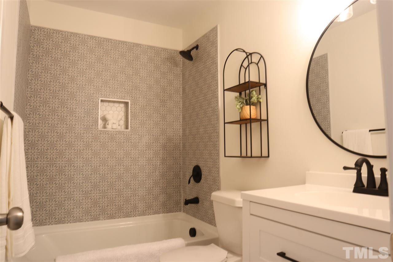 7009 Kiger Road Rougemont, NC 27572 - Photo 14 of 25 a bathroom with a sink a mirror and a bathtub
