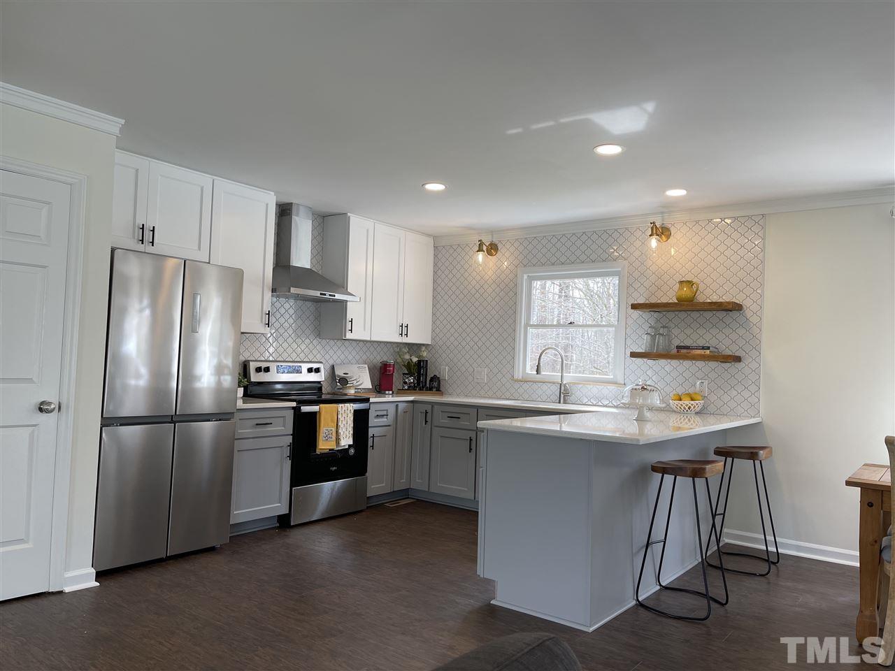 7009 Kiger Road Rougemont, NC 27572 - Photo 10 of 25 a kitchen with stainless steel appliances granite countertop a sink a stove a refrigerator and island