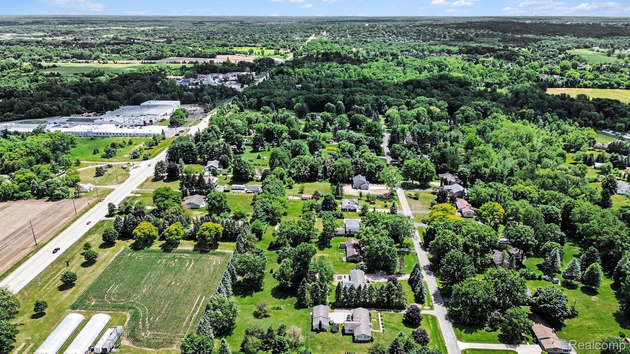 74600 Nordman Court Romeo, MI 48065 - Photo 28 of 32 Expansive aerial perspective showcasing a residential area with mature tree coverage