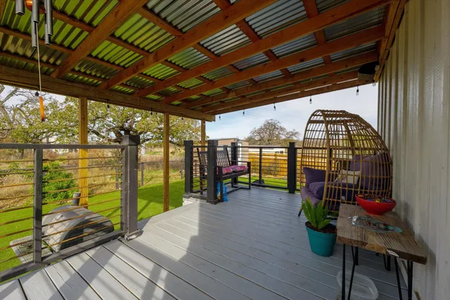 a view of a porch with wooden floors and trees