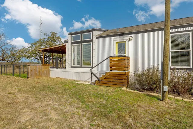 a view of a house with backyard and sitting area