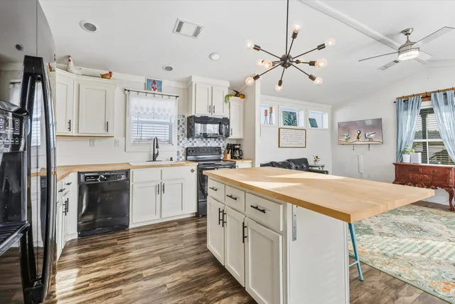 a kitchen with kitchen island granite countertop a sink appliances cabinets and a counter top space