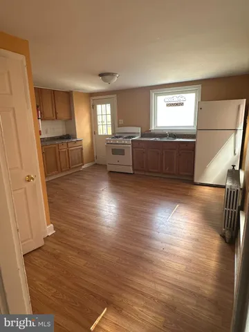 a view of a kitchen with furniture and wooden floor