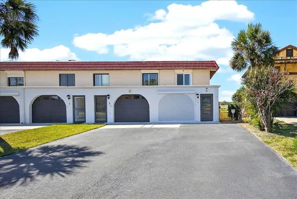 a front view of a house with yard and garage