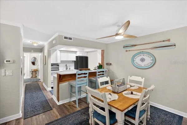 a living room with furniture a clock and a view of kitchen