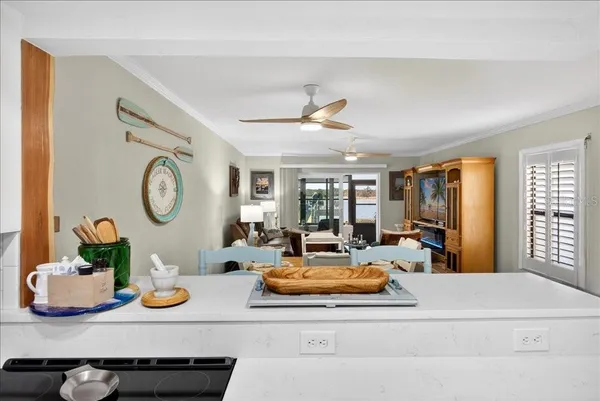 a living room with furniture kitchen view and a window