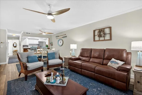 a living room with furniture a ceiling fan and a rug