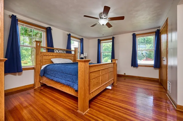 a bedroom with a bed and large windows
