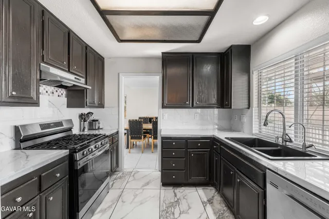 a kitchen with stainless steel appliances granite countertop a sink stove and cabinets