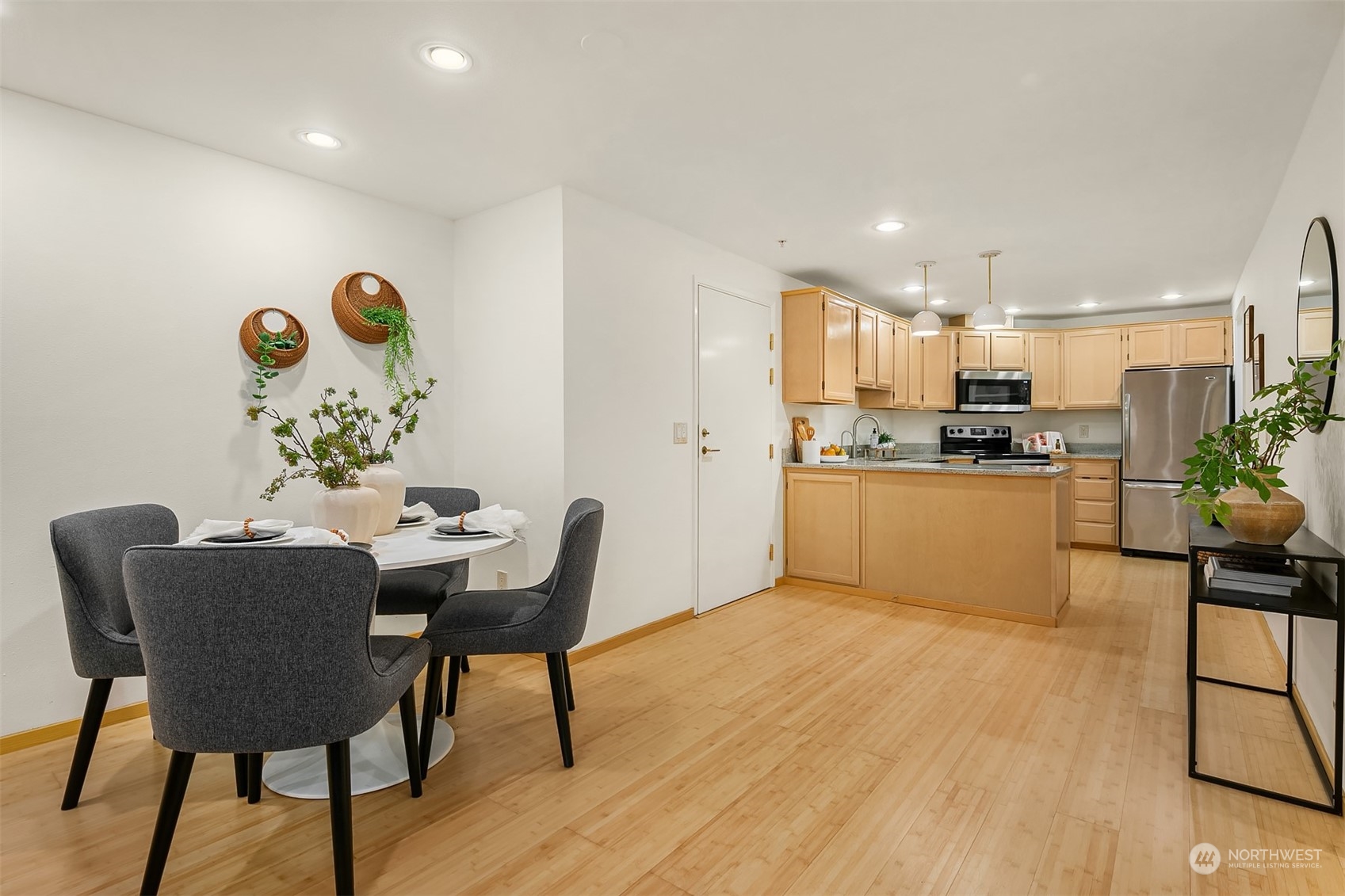 1110 West Howe Street, Unit 202 Seattle, WA 98119 - Photo 5 of 15 a kitchen with a dining table chairs and refrigerator