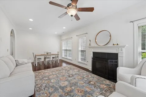 a living room with furniture a fireplace and a chandelier