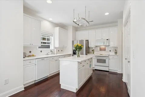 a kitchen with white cabinets and white appliances