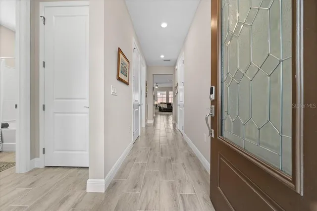 a view of a hallway with wooden floor and staircase
